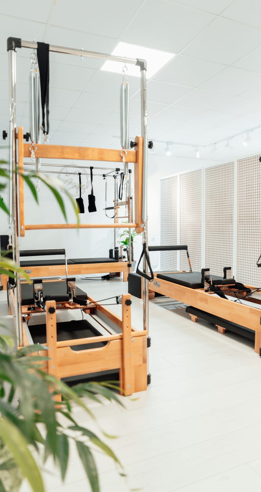Un professeur de yoga aide un élève à faire le poirier dans un studio paisible.